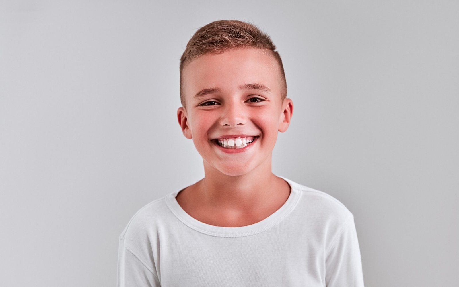Nurturing Healthy Smiles: The Impact of Fluoride Treatments for Kids 2 Cute boy on a gray